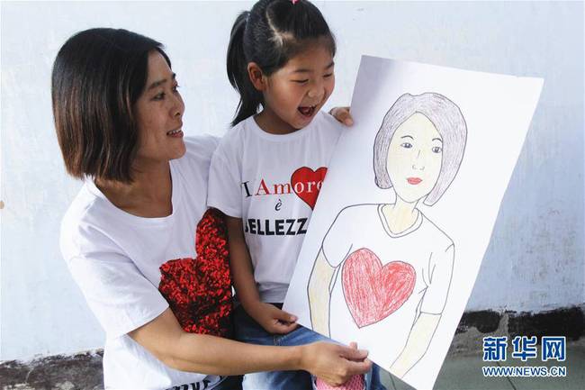 5月10日，在河北唐山市豐潤區(qū)迎賓路幼兒園開展的“媽媽，我愛你”主題活動中，陳悅寧小朋友將自己的繪畫作品送給媽媽作為節(jié)日禮物。 新華社發(fā)（朱大勇 攝）