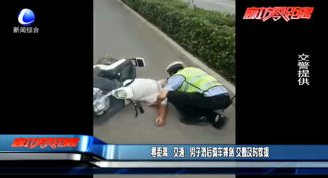 男子酒后騎車摔倒 交警及時救援